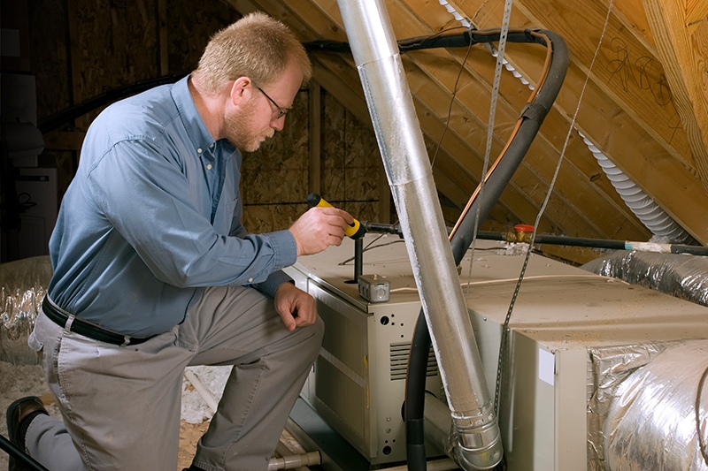 Maintenance man fixing a furnace.